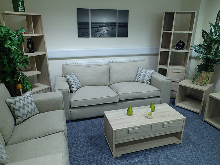 Living roomfFurniture on display, including sofas, tables, and bookshelves.